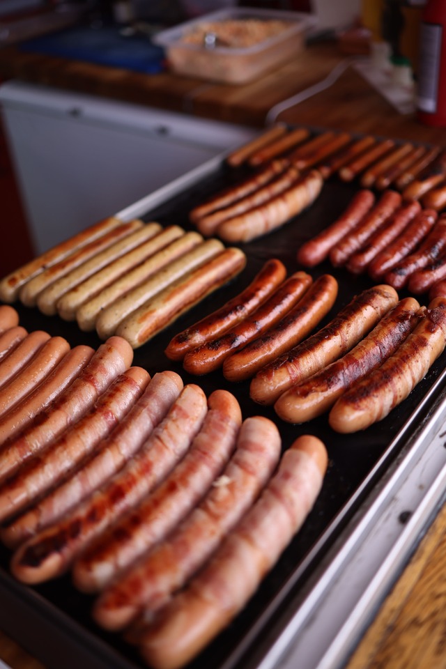 Saucisses en cuisson sur une plancha électrique